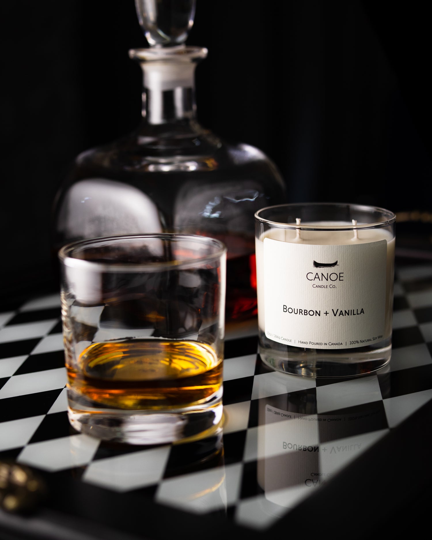 CANOE Candle Co.'s Bourbon + Vanille 10oz soy wax candle with a reused glass container with bourbon.
