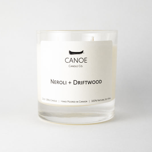 Canoe Candle Co.’s Neroli + Driftwood 10oz soy wax candle on a plain white background.